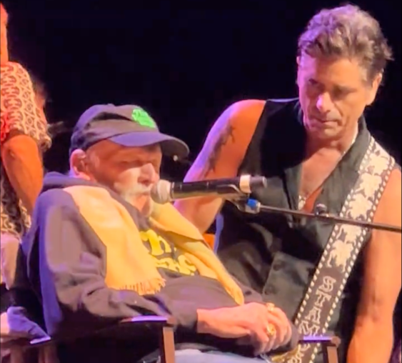 John Stamos Defends Mike Love’s Alarming Live Return: “He Insists On Being On Stage” image